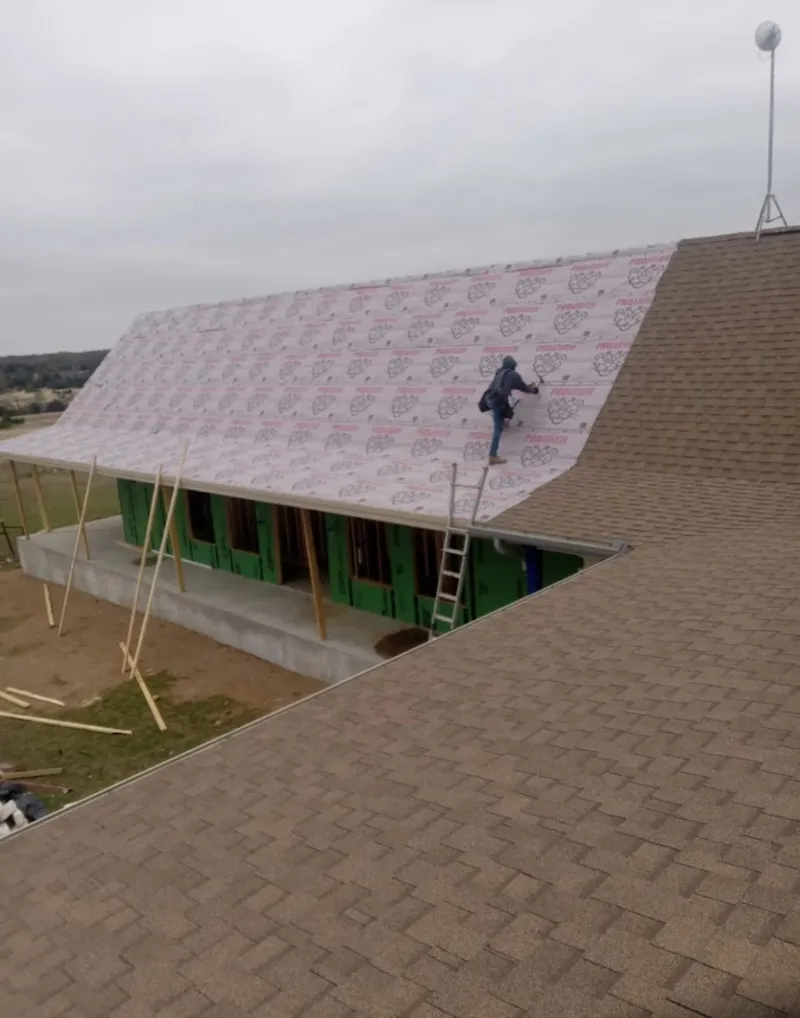 Worker preparing underlayment for a metal roof installation in Fruitland Park